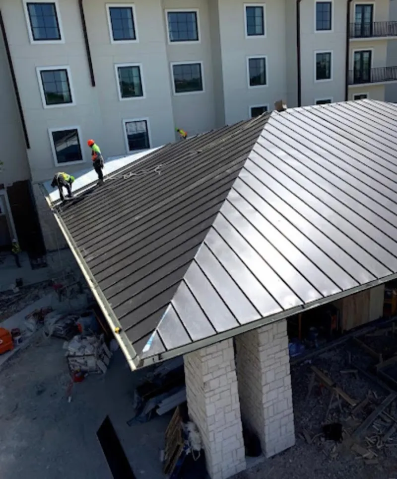 Crew installing standing seam metal roof panels on a commercial project in Palm Harbor